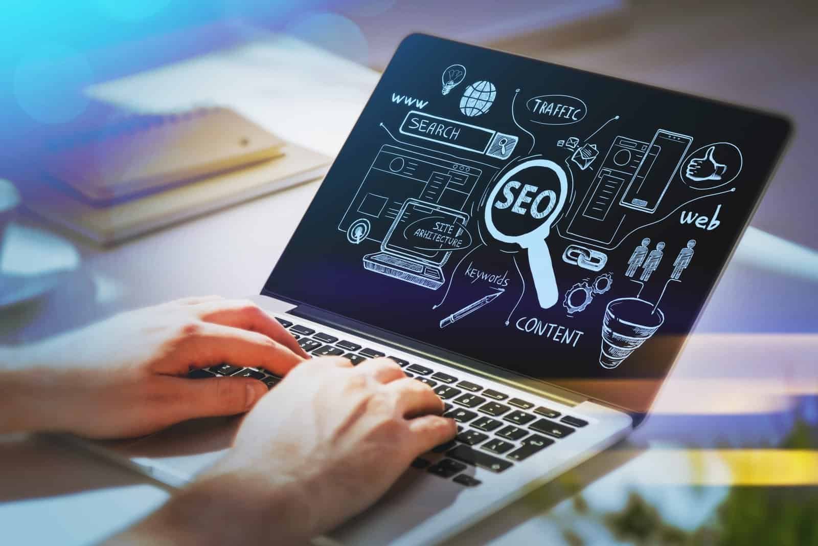 Person working on SEO strategy with digital graphics on laptop screen.